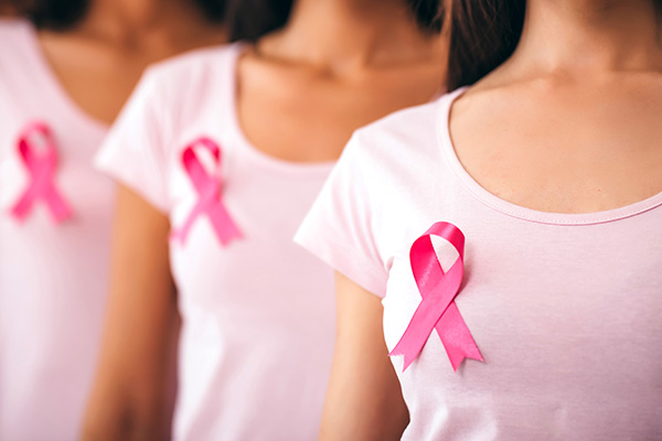 Women wearing pink shirts with pink ribbons for breast cancer awareness (stock image)
